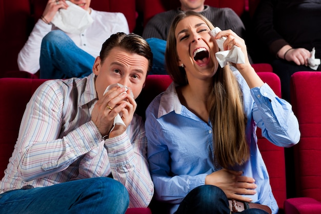 Pareja y otras personas en el cine.