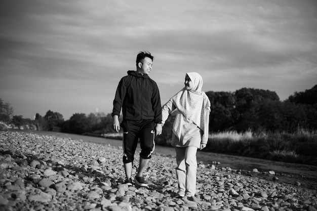 Una pareja paseando por un río con un río de fondo.