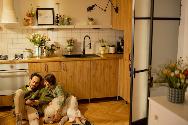 Pareja con perro en la cocina de casa