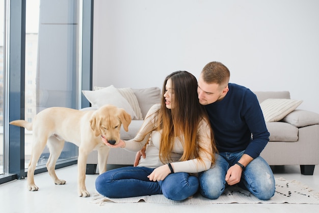 Pareja con perro sentado en casa