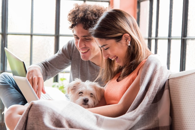 Foto pareja con perro trabajando en casa