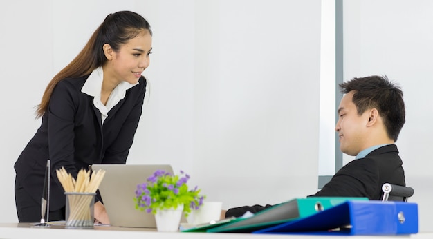 Pareja de personas asiáticas de oficina, mujer y hombre, empleados, compañeros de equipo hablando sobre el plan de trabajo, se ven cómodos e informales, se sienten muy felices en el lugar de la oficina.