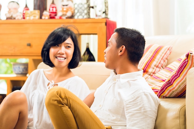 Pareja de personas asiáticas en la sala de estar