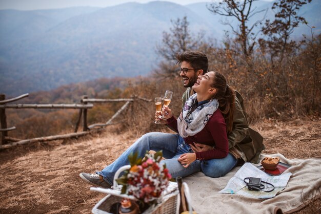 Pareja de picnic. Pareja sentada en una manta y bebiendo vino.