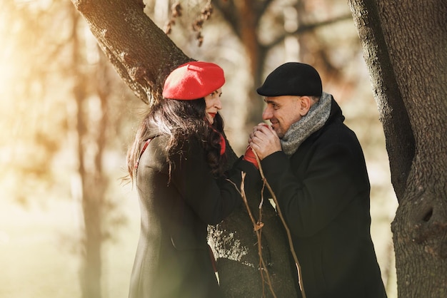 Una pareja de pie junto a un árbol en el parque