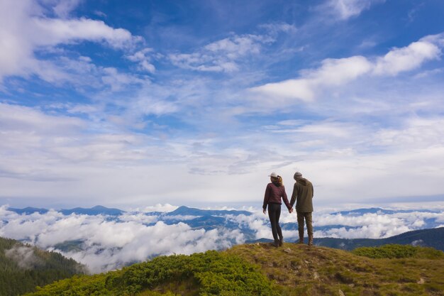 La pareja de pie en la pintoresca montaña.