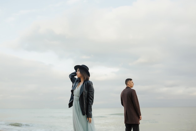 pareja de pie en una playa junto al mar