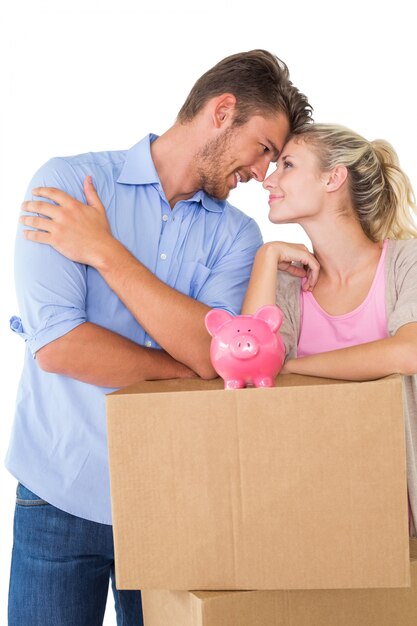 Pareja con piggybank sobre caja de cartón