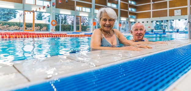 Una pareja en una piscina con una piscina al fondo.