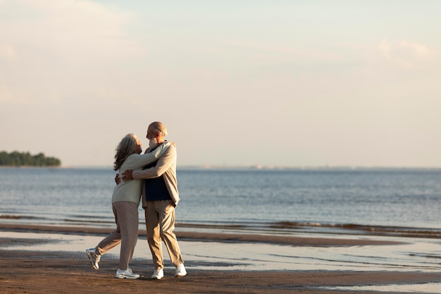 Foto pareja, en, playa, abrazar, tiro completo