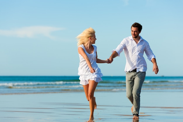 Pareja en la playa corriendo hacia un futuro glorioso