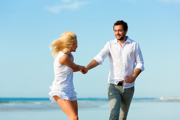 Pareja en la playa corriendo hacia un futuro glorioso