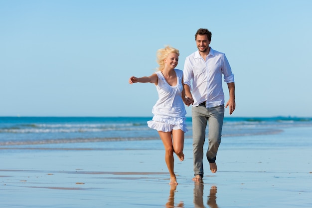 Pareja en la playa corriendo hacia un futuro glorioso