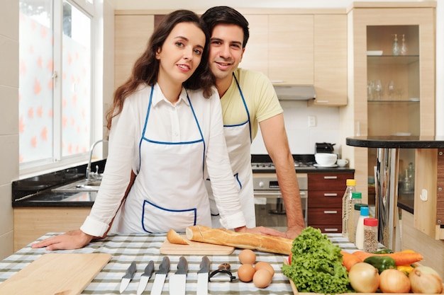 Pareja positiva de pie en la cocina