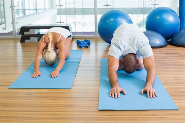 Pareja en postura de flexión en el gimnasio