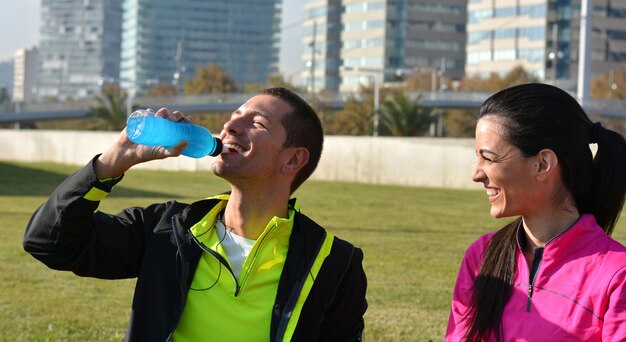 Pareja practicando correr en la ciudad en un día soleado