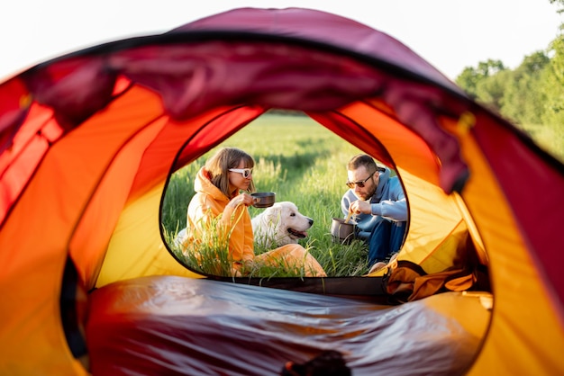 Pareja prepara comida mientras viaja con carpa en la naturaleza