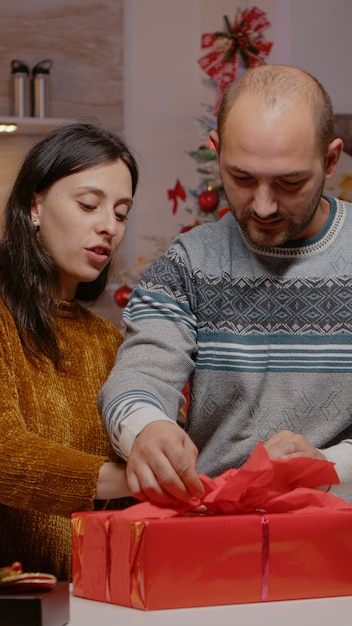 Pareja preparando caja de regalo para la familia en la fiesta de Nochebuena