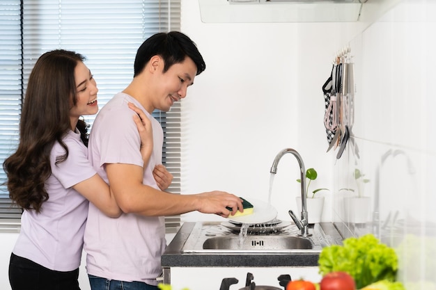 Foto pareja con preparar verduras para cocinar juntos en la cocina en casa mujer está abrazando al hombre