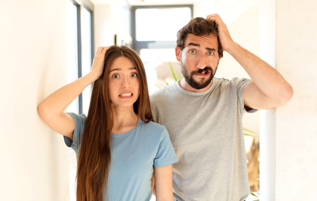 Foto pareja que se siente estresada, preocupada, ansiosa o asustada, con las manos en la cabeza, en pánico por el error