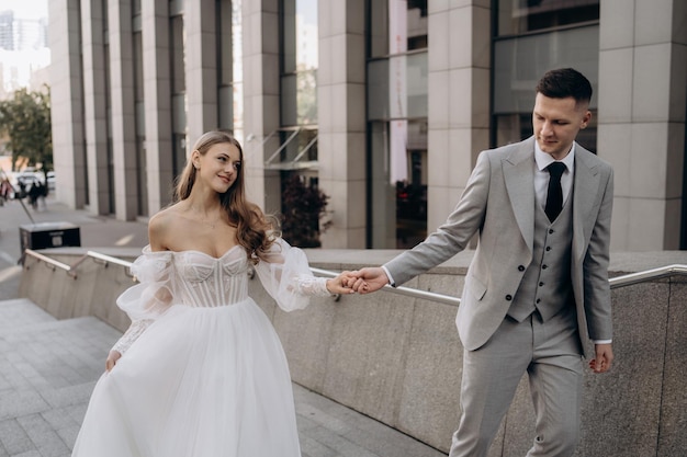 Pareja de recién casados europeos caminando por la calle el día de su boda en la ciudad