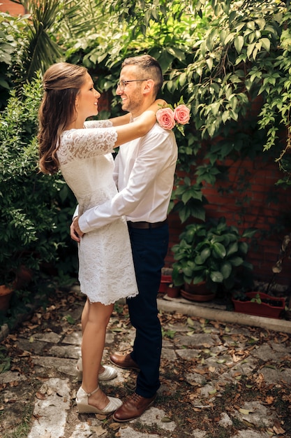 Pareja de recién casados mirándose abrazando baile y sonriendo en el día de su boda. concepto de unión y amor.