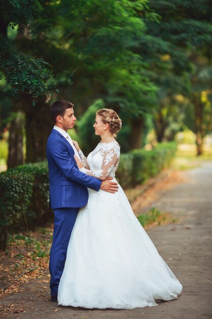 Pareja de recién casados en el parque. Recién casados. Camina por el parque y abraza.