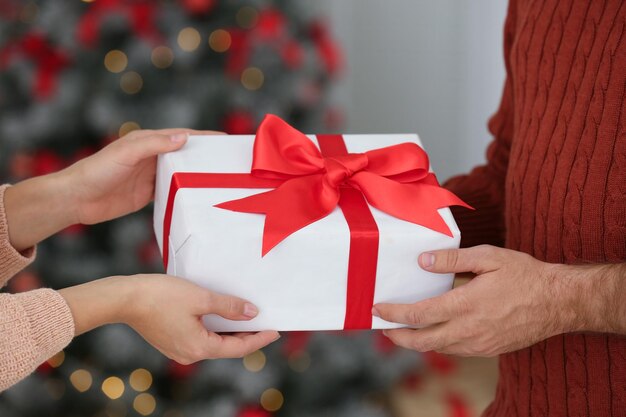 Pareja con regalo de Navidad en casa closeup