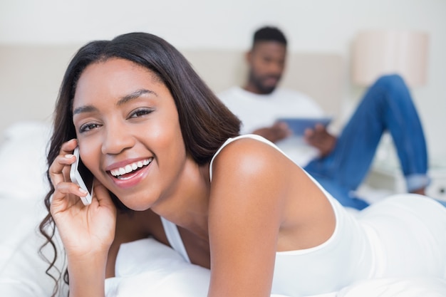 Pareja relajada utilizando la tecnología en la cama