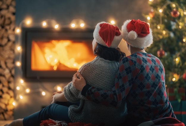 Una pareja relajándose cerca del árbol de Navidad