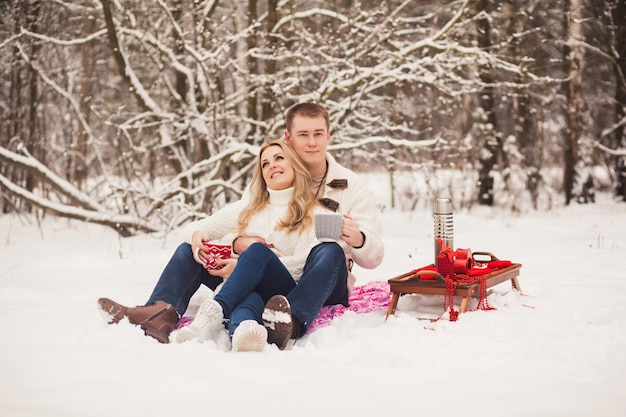 Pareja relajante en el bosque de invierno