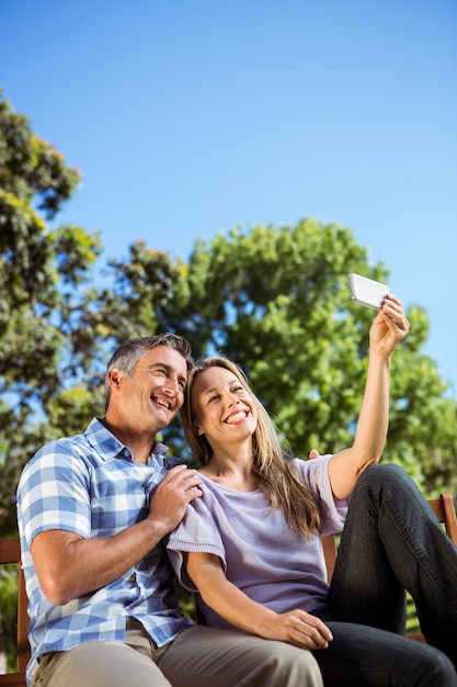 Pareja relajante en el parque en el banco