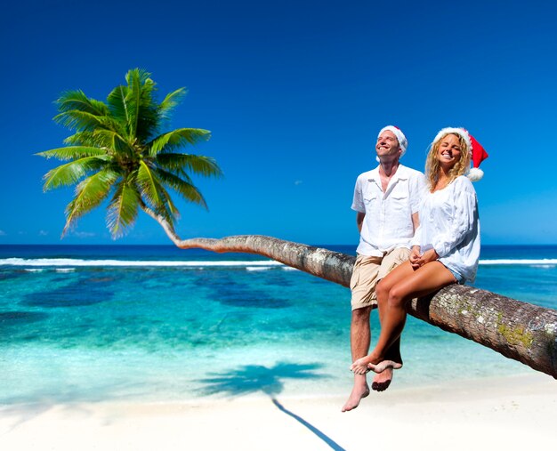 Pareja relajante en la playa durante la Navidad