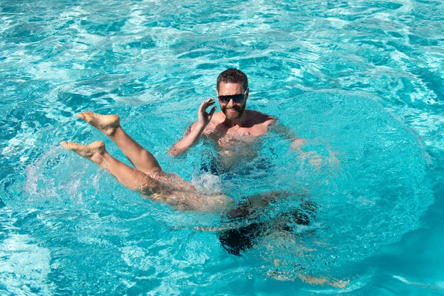 Pareja de resort de piscina de verano en la piscina ocio activo de verano