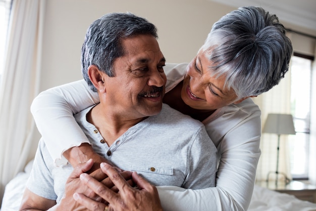 Pareja romántica abrazando en dormitorio