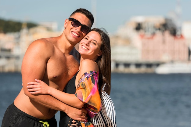 Foto pareja romántica abrazándose en la playa con espacio de copia