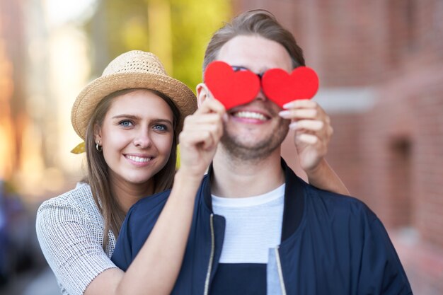 Foto pareja romántica adulta sosteniendo corazones en el paseo por la ciudad