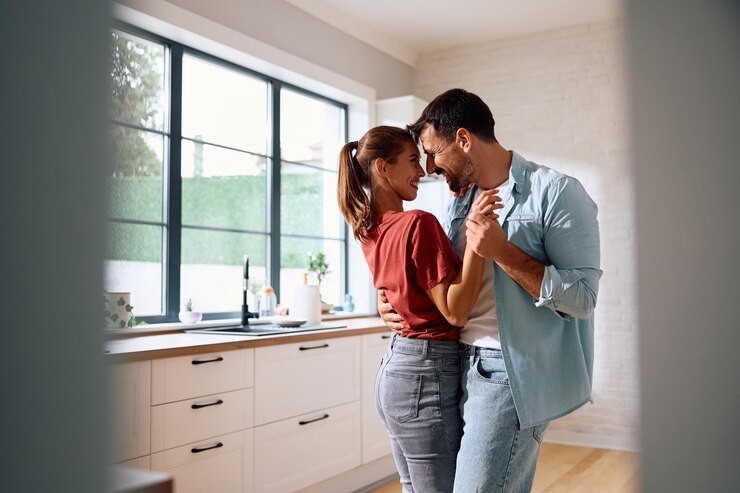 Foto una pareja romántica bailando en la cocina de su casa.
