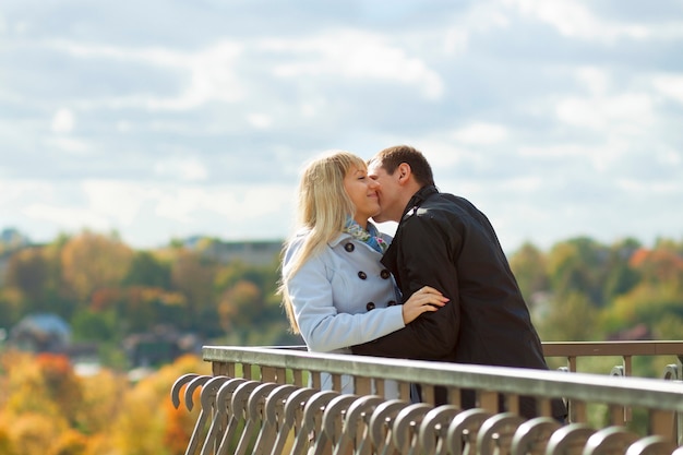 Pareja romántica besándose en el parque otoño