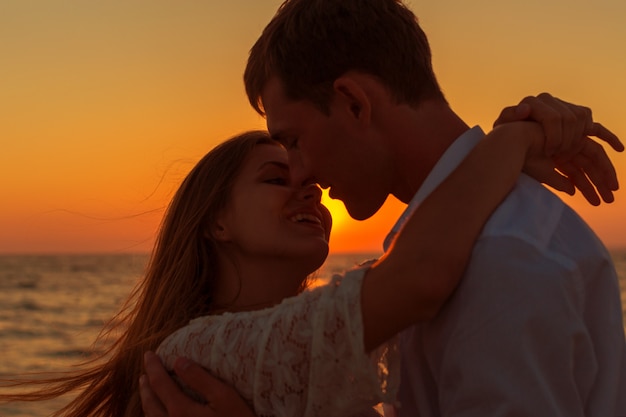 Pareja romántica besándose en la playa