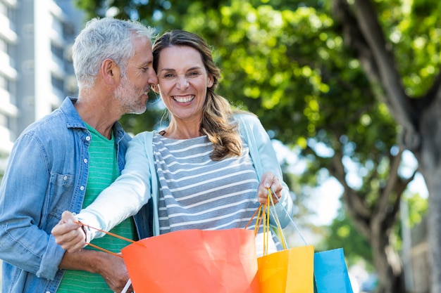 Pareja romántica con bolsas de compras en la ciudad