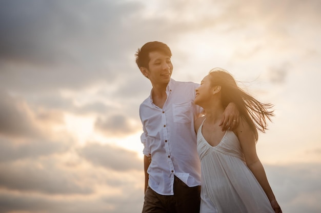 Pareja romántica caminando abrazándose mientras está en la playa al amanecer, planificar un seguro de vida en el futuro concepto. Copie el espacio para el texto. pareja, amor, playa, romántico, verano, concepto de estilo de vida.