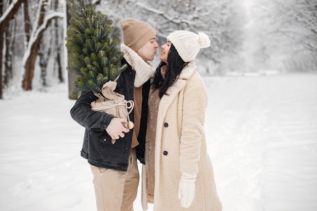 Pareja romántica caminando en el bosque en el día de invierno