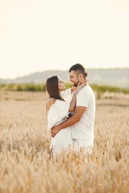 Pareja romántica en el campo de trigo en un día soleado