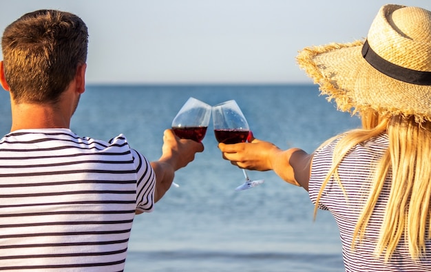 Pareja romántica disfrutando del vino junto al mar