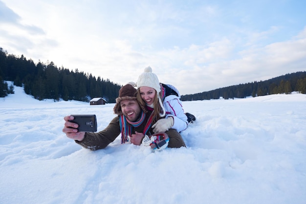 Foto una pareja romántica se divierten en la nieve fresca y se toman selfies.