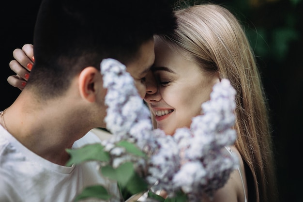 Una pareja romántica enamorada besándose y sosteniendo una flor en el parque