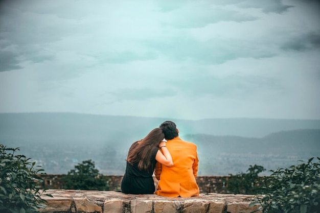 pareja romántica india sentada frente a la montaña