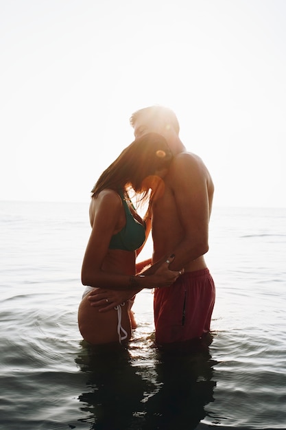 Foto pareja romántica en el mar al atardecer