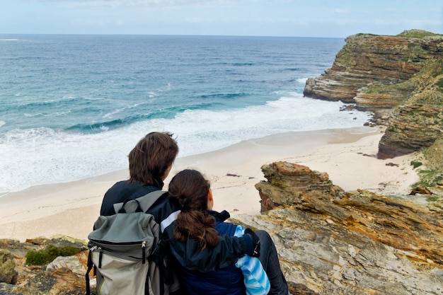 Pareja romántica mirando hermosa vista del cabo de buena esperanza y el océano. Vacaciones de luna de miel en Sudáfrica